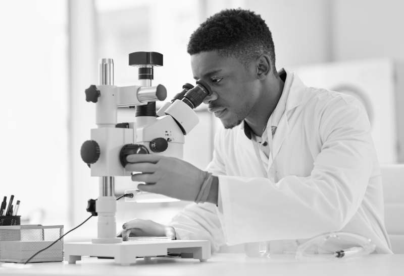 SINGLE-IMAGE_scientist-looking-at-test-samples-through-a-microscope_mar25