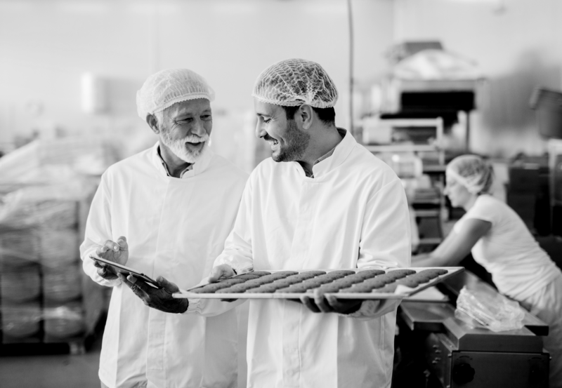 SINGLE-IMAGE_man-with-tablet-checking-tray-of-biscuits_nov23