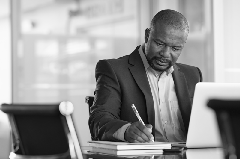 SINGLE-IMAGE_man-with-pen-and-books-at-desk_feb24