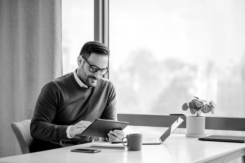 https://brandportal.ideagen.com/m/673a5ea71e3e5251/webimage-SINGLE-IMAGE_man-with-tablet-at-desk-with-plant_feb24.png