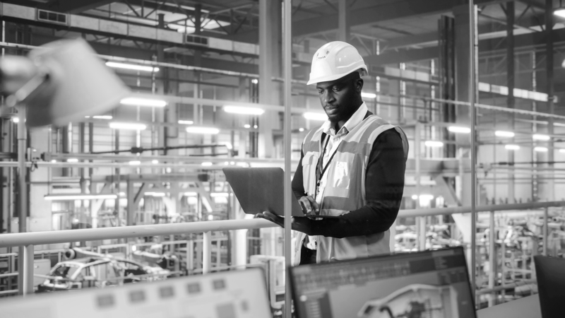 https://brandportal.ideagen.com/m/7416202ca7d23dac/webimage-SINGLE-IMAGE_man-hard-hat-in-factory-with-laptop_oct23.png